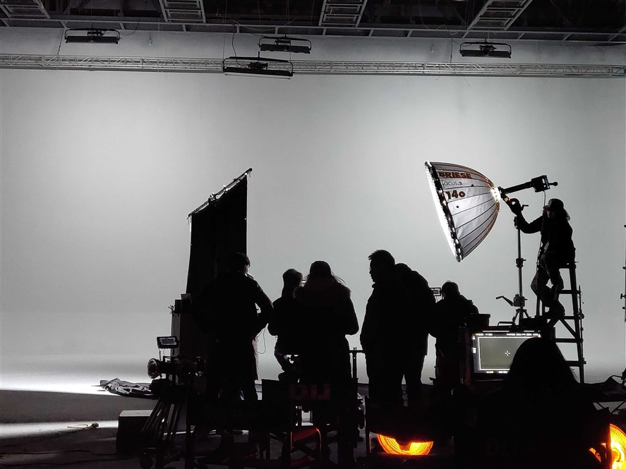 Indoor Shenzhen production setup with crew, lighting, and camera gear on a studio stage